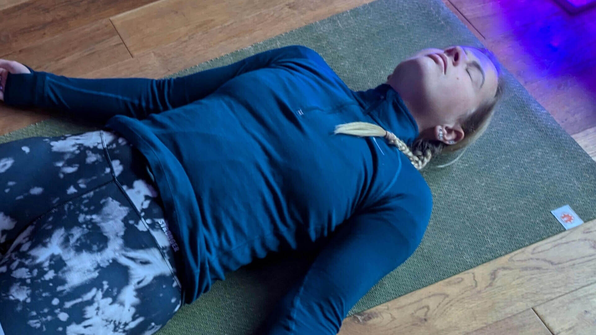 A women practicing Shavasana during a Yoga Nidra session
